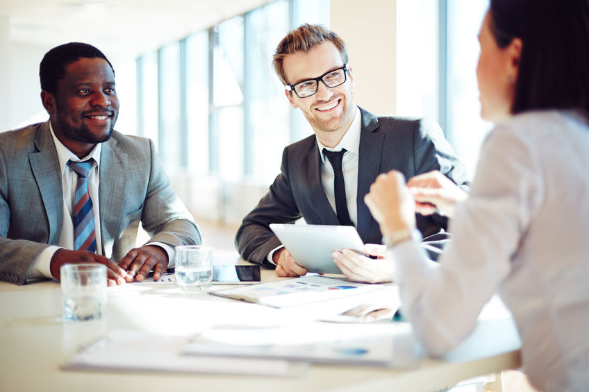 smiling colleagues discussing working ideas in office
