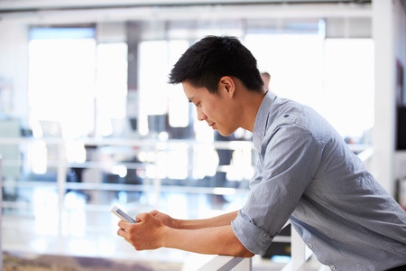 portrait of young man using smart phone in an office