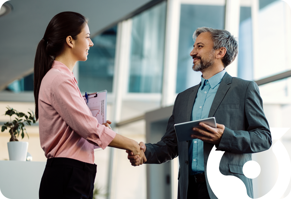 Two professionals shaking hands in modern office environment
